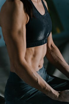 Close-up of a muscular woman resting during an intense workout session indoors.