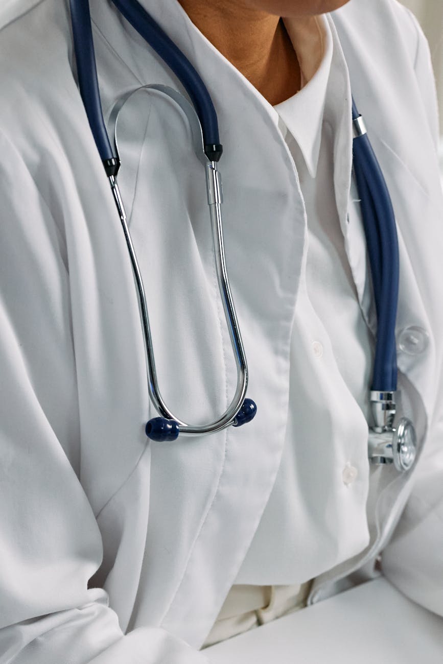 Close-up of a healthcare professional's stethoscope draped around a white coat, symbolizing clinical care.